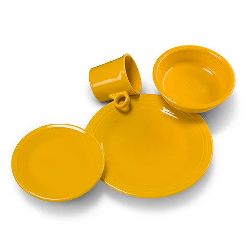 Fiesta vibrant sunflower yellow 4-piece ceramic dinnerware set including a dinner plate, salad plate, bowl, and teacup.