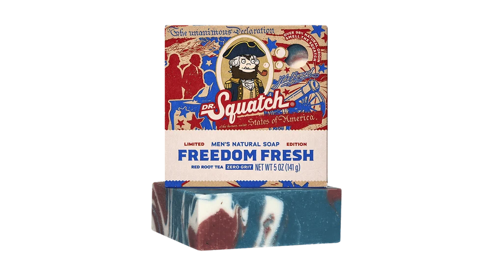 Dr. Squatch Freedom Fresh natural soap bar featuring red, white, and blue swirled patterns resting beneath a Patriotic red, white, and blue box.
