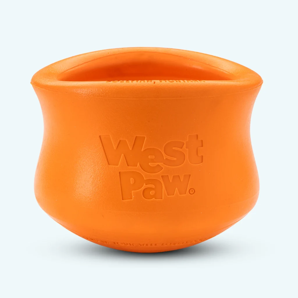 Bright orange West Paw Toppl treat-dispensing rubber dog toy shown upright against a light background.