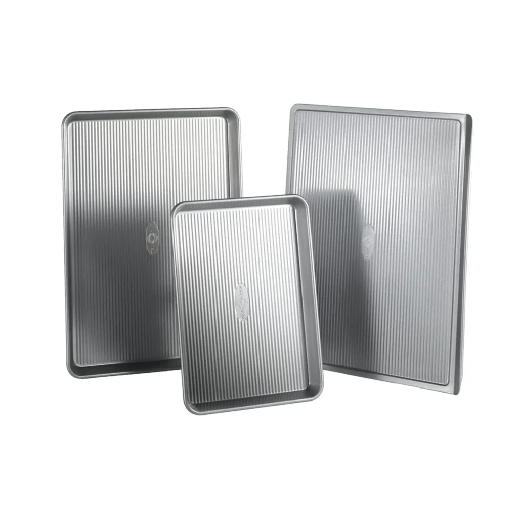 USA Pan 3-Piece Sheet Pan Set made of heavy-gauge aluminized steel with corrugated surface on white background.